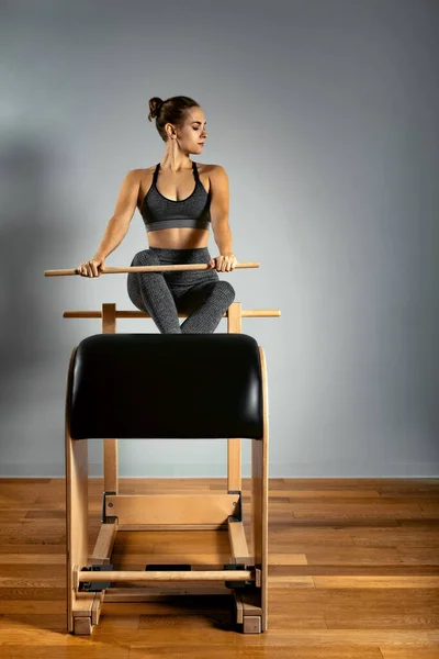 Pilates trainer exercises on a pilates barrel. Body training, perfect body shape and posture correction opporno motor apparatus. Copy space.