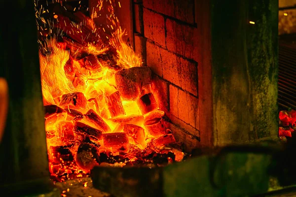Piec w restauracji ze spalonym węglem. Łopatka wrzuca węgiel do pieca z posiekanym węglem. — Zdjęcie stockowe