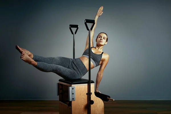 Pilates riformatore sedia donna fitness yoga palestra esercizio. Correzione del sistema muscolo-scheletrico, bel corpo. Posizione corretta — Foto Stock