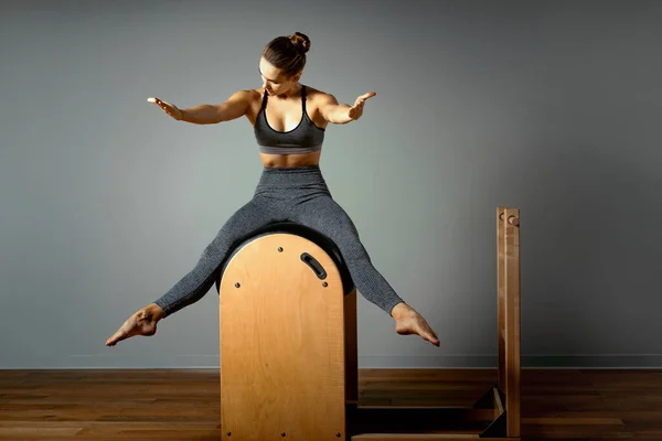 Pilates, idoneità, sport, formazione e concetto della gente - donna che fa esercizi su un piccolo barile. Correzione dell'apparato impellente, corretta postura . — Foto Stock