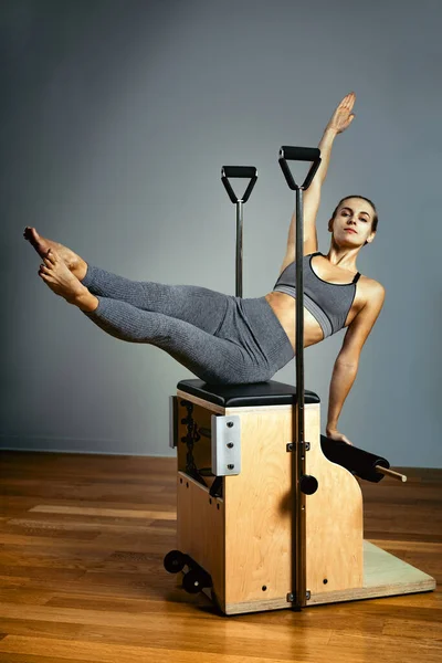 Pilates reformer chair woman fitness yoga gym exercise. Correction of musculoskeletal system, beautiful body. Correct posture