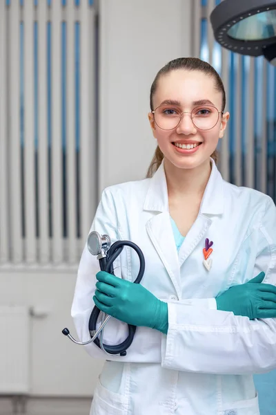 Portrait of a doctor looking at the camera. A young woman is smiling. Health care, medical. Combined medicine, spanien of lives, oath to a hypocrat. copy space