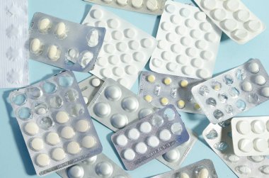 Kabarcıklar mavi arka plana saçılmış. Kabarcıkların yarısı dolu. İlaçlar