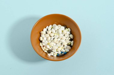 Mavi arka planda ilaçlı plaka. Çok fazla hap. Tıp teması mavi arkaplan.