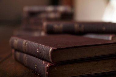 Eski kitaplar rustik ahşap masa üzerinde. Kitap yığını. Arka plan bulanık. Rustik, kahverengi ve sıcak sahne.