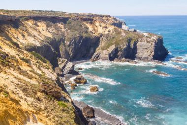 Dalga ve Almograve Beach'te kayalıklarla