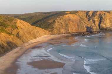 Gün batımı, kayalıklar, sahil ve Arrifana dalgalar