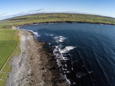 Çiftlikleri ve Anneleri Uçurumları olan kumsal manzarası