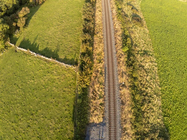 Aerial view of a train rail with farm fields