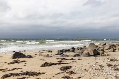 Bertra sahilinde bulutlu bir günde dalgalar ve kayalar
