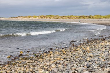 Bertra sahilinde bulutlu bir günde dalgalar ve kayalar