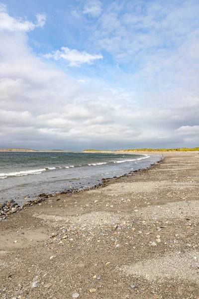 Golven en rotsen op het strand van Bertra in bewolkte dag — Stockfoto