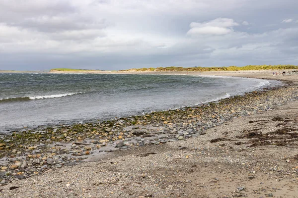 Fale i skały na plaży Bertra w pochmurny dzień — Zdjęcie stockowe