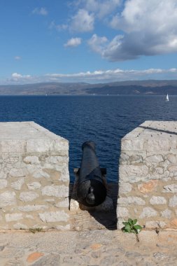 Hydra adasında, arkasında okyanus olan eski bir kale topu.