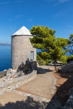 Hidra Adası 'nın arka planında okyanus olan eski rüzgar değirmeni