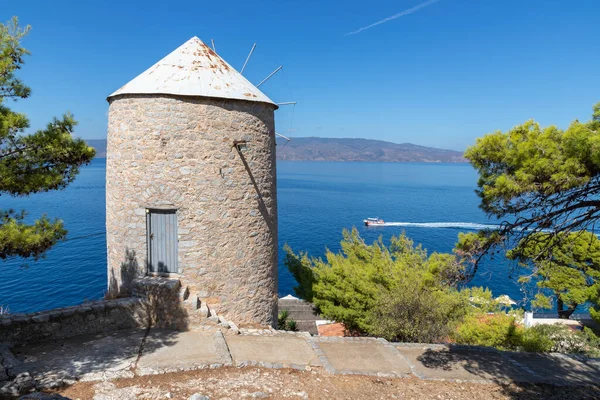 Hidra Adası 'nın arka planında okyanus olan eski rüzgar değirmeni