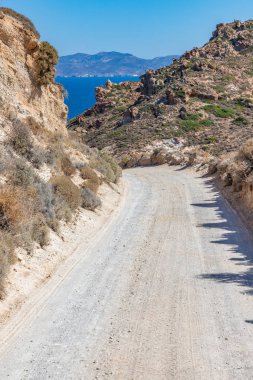 Okyanus ve arka planda dağlar olan kirli bir yol.