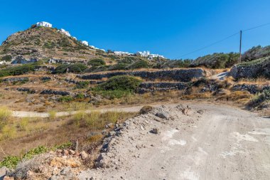 Taşları, bitkileri ve Plaka köyü olan kirli bir yol.