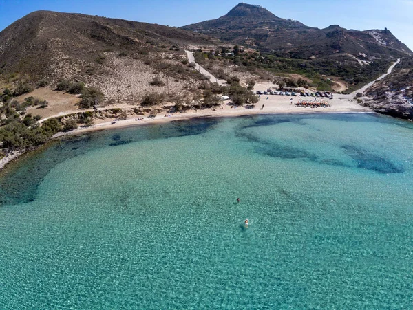Playa de Plathiena con el hombre nadando, montañas y vegetación — Foto de Stock