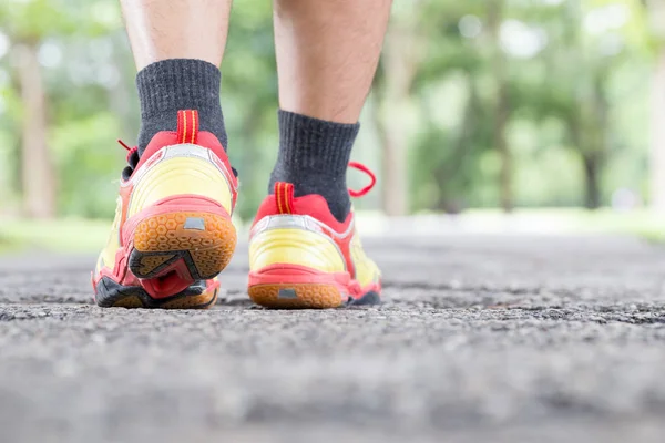 Bein des Mannes läuft auf Straße in öffentlichem Park und Nahaufnahme Schuh — Stockfoto