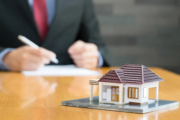 Businessman signing a contract to loan real estate — Stock Photo, Image