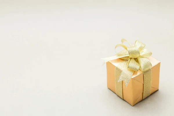 Gold gift box on brown paper background — Stock Photo, Image