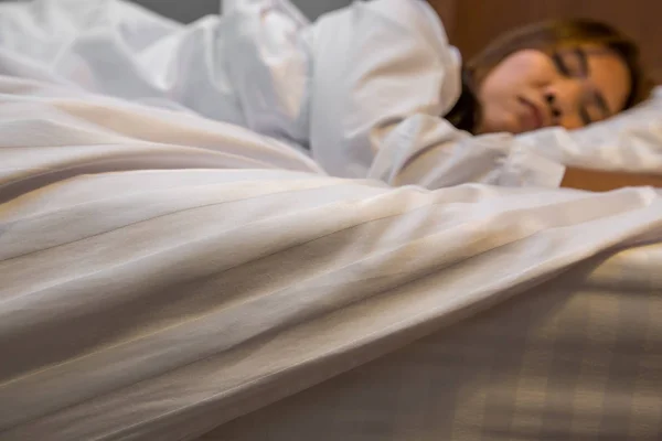 Spanie w łóżku Asian kobieta. skupić się na pościel — Zdjęcie stockowe