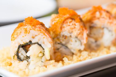 Beyaz tabakta somon suşisi rulosu