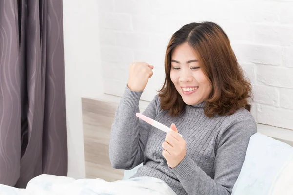 Feliz asiático mujer holding embarazo prueba —  Fotos de Stock