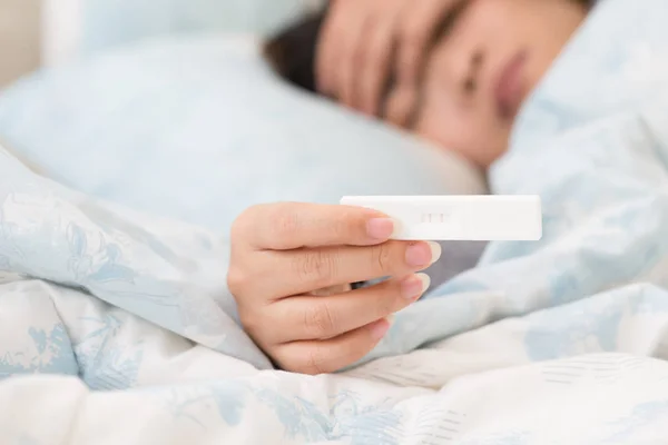 Mujer acostada exhausta en la cama después de las náuseas matutinas . —  Fotos de Stock