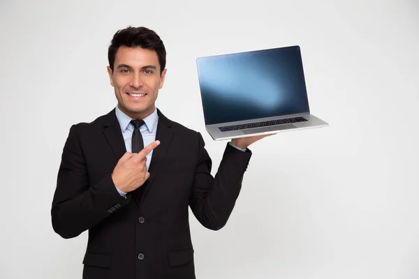 Genç işadamı bir dizüstü bilgisayar gösteriyor ve uygulama, web sitesi veya ürünlerin sunumu için kopya alanı olan bir ekrana işaret ediyor — Stok fotoğraf