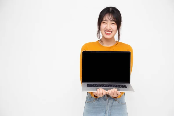 Jeune femme asiatique montrant un ordinateur portable sur fond blanc avec espace de copie pour présenter une application ou un site Web en ligne ou des produits — Photo