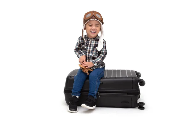 Niño feliz chico asiático sonriendo y sentado en una maleta negra — Foto de Stock