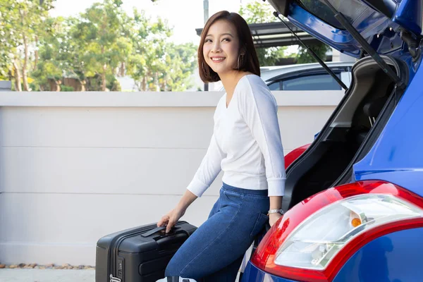 Joven mujer asiática empacando maletas en el maletero de su coche para viajar vacaciones de verano — Foto de Stock