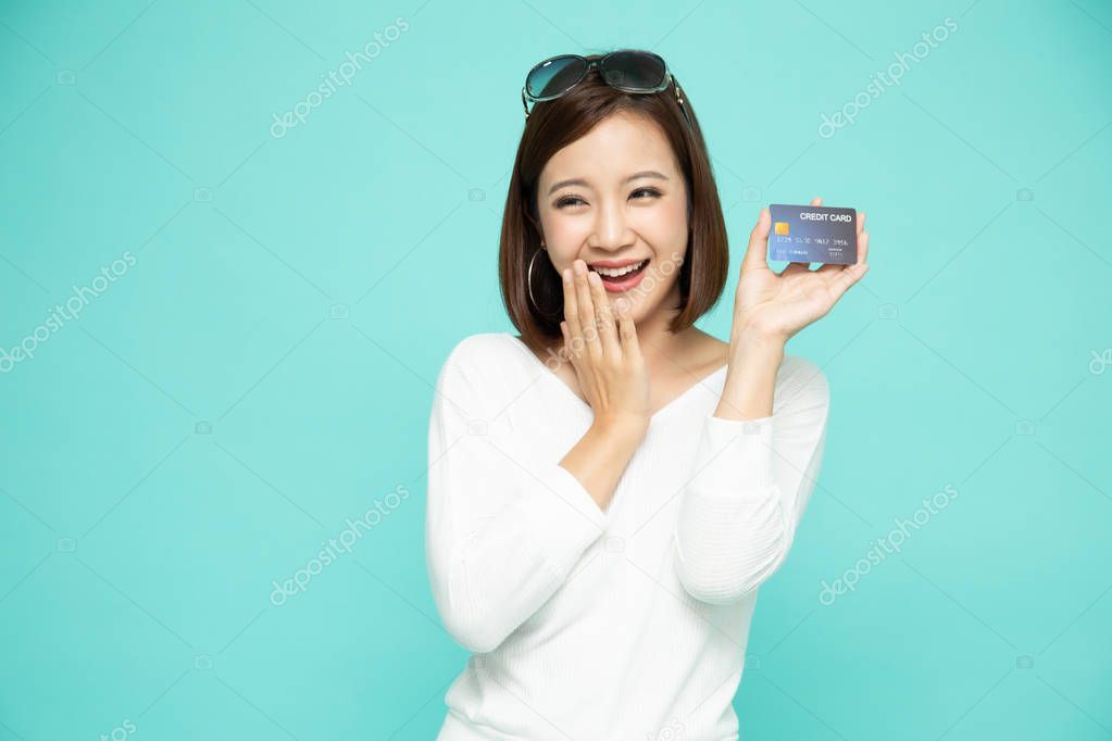 Happy Asian woman in white shirt holding credit card or cash 