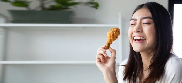 Mladá asijská žena jíst kuře v pokoji doma a pocit štěstí potěšení — Stock fotografie