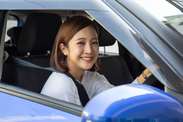 Las mujeres asiáticas que conducen un coche y sonríen felizmente con expresión positiva alegre durante la impulsión al viaje, la gente goza el transporte de la risa y la mujer feliz relajada en concepto de vacaciones del roadtrip —  Fotos de Stock