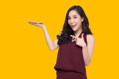 Mutlu Asyalı kadın ürün için fotokopi alanı sunuyor ya da gösteriyor 