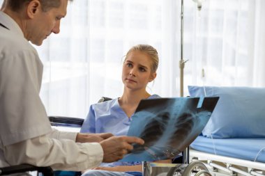 Hastanedeki hastanın göğüs röntgenini inceleyen doktor. Solunum sendromu veya viral zatürree semptomu