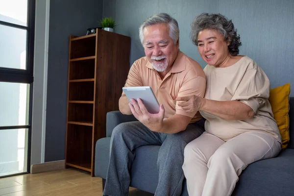 Pareja Asiática Seniors Sonriendo Mirando Misma Tableta Sofá Casa Hombre — Foto de Stock