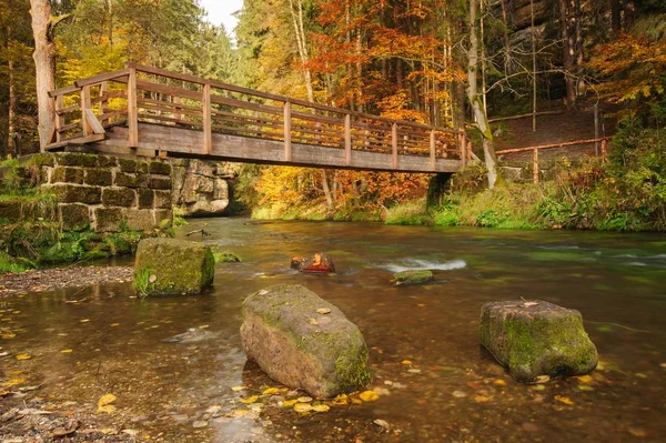 Herfst kleuren rivier met houten brug — Stockfoto
