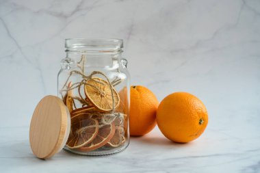 Noel süsü olarak kurutulmuş portakal dilimleri kavanozda ve taze portakal meyveleri birlikte. 