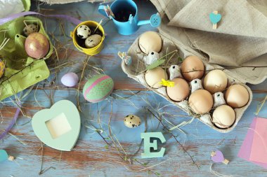 Pakette taze yumurta, ahşap bir arka planda Paskalya süslemesi, üst manzara, bayram kutlamaları için hazırlık.