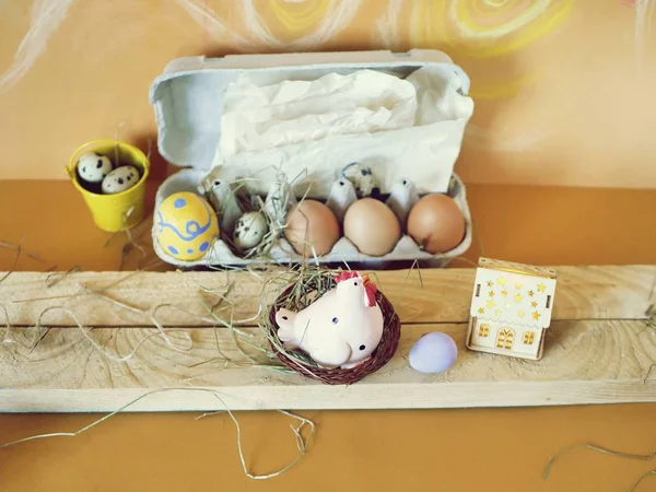Easter decor, eggs, toy chicken on a light wooden table