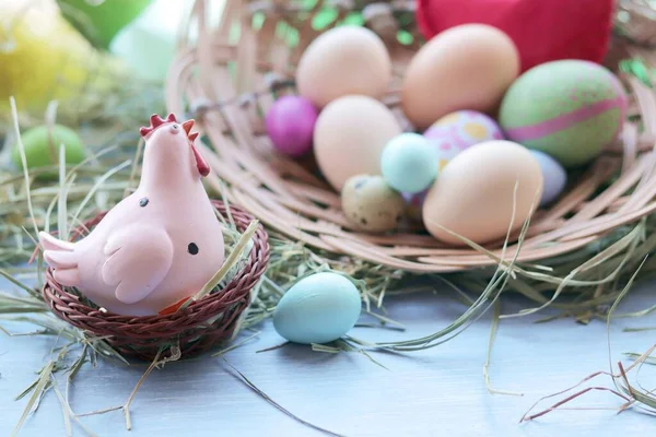 Happy Easter, a basket with painted eggs, a toy chicken, hay on the windowsill, interior decor for the holiday