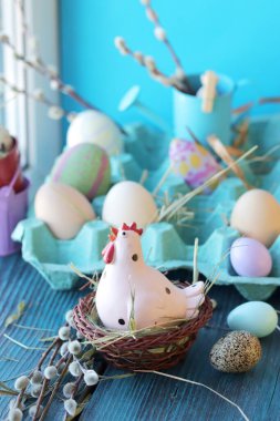Paskalya oyuncağı tavuk, ahşap pencere eşiğinde yumurta bahar, şenlikli ev dekorasyonu.