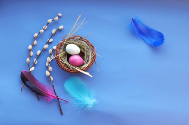 Mutlu Paskalyalar, dekorlar, boyanmış yumurtalar, mavi arka planda parlak tüyler
