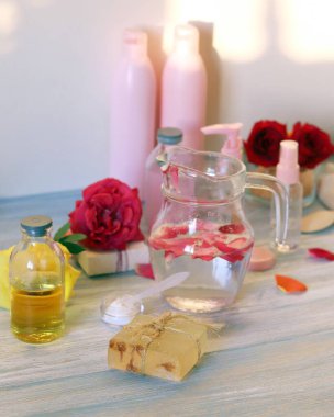 Taze güller, sabun, taç yaprakları, su ve yağ evde doğal kozmetik ürünlerinin hazırlanması için masada, sağlıklı bir yaşam tarzı