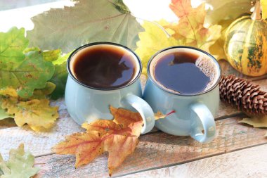 İki fincan kahve, balkabağı, arka planda yapraklar, ev konforu, aile mahremiyeti, Şükran Günü, sonbahar sezonu
