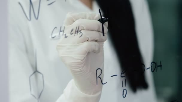 Mujer en laboratorio escribir fórmula en el tablero de vidrio — Vídeos de Stock